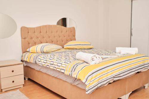 a bedroom with a bed with a yellow and white comforter at Şehrin Ortasında Uygun ve Aile İçin Apart in Sivas