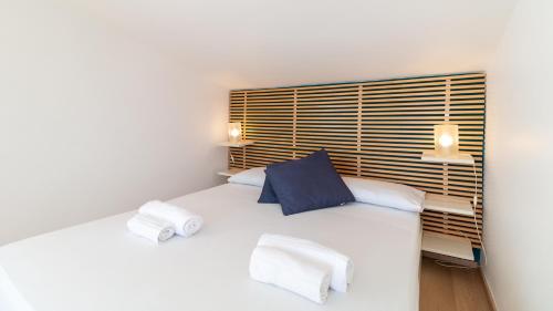 a bedroom with a white bed with two pillows at Villa Marina-S'Arena Scoada by Sardinianworld in Putzu Idu
