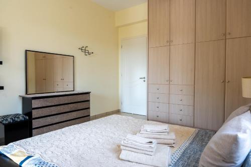 a bedroom with a bed with a dresser and a television at Beautiful Summer Villa in Chalkoutsi in Khalkoútsion
