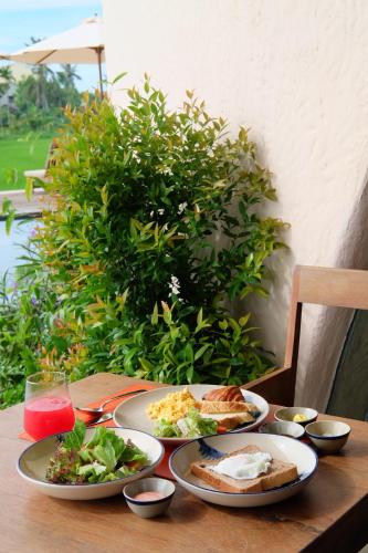 a wooden table with plates of food on it at Reu Boutique Hotel in Hoi An
