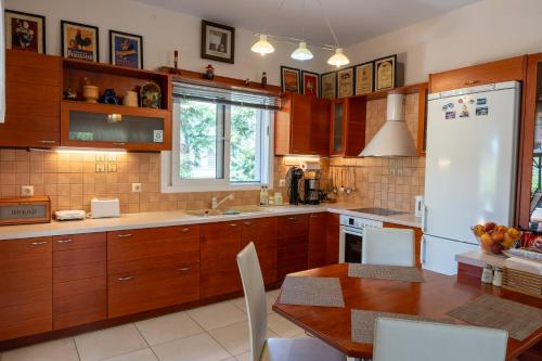a kitchen with a table and a white refrigerator at Beautiful Summer Villa in Chalkoutsi in Khalkoútsion
