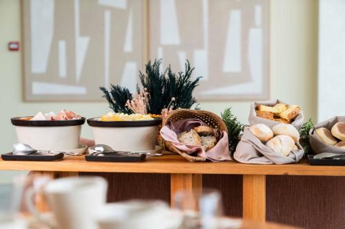 a table topped with bowls of bread and snacks at The Farm - Azores Boutique House in Ponta Delgada