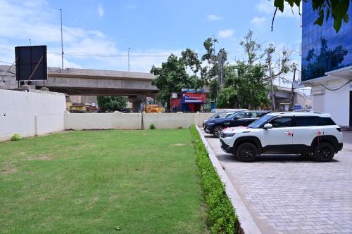 a white suv parked on the side of a street at Date Palm Hotel in Gurgaon