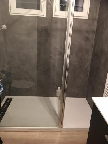 une douche avec une porte vitrée dans une salle de bain dans l'établissement Les Tamaris d'Audenge, à Audenge
