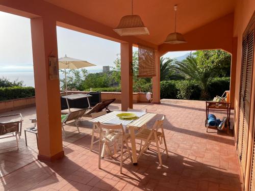 a patio with a table and chairs on a patio at Villa Hibiscus Scopello in Scopello