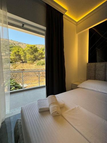 a bedroom with a bed and a window with a view at Nōya Suites SR in Sarandë