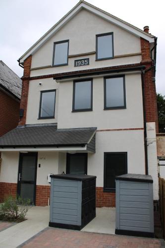 a white house with black doors and windows at White House apartment, Staines upon Thames in Staines upon Thames