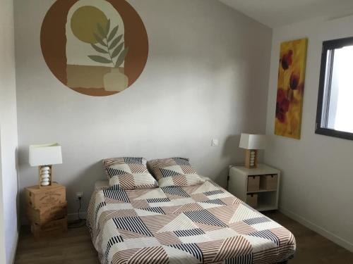 ein Schlafzimmer mit einem Bett und zwei Nachttischen mit Lampen in der Unterkunft Maison 2ch, Parking, à 10min de Bx, Calme in Mérignac