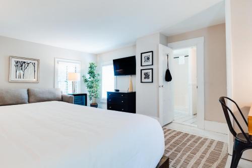 a white bedroom with a bed and a couch at Waterford Inn Provincetown in Provincetown