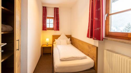 a small room with two beds and a window at Alpenhotel Oberstdorf - ein Rovell Hotel in Oberstdorf
