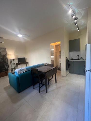 un salon avec un canapé bleu et une table dans l'établissement Studio proche mer Antibes centre, à Antibes
