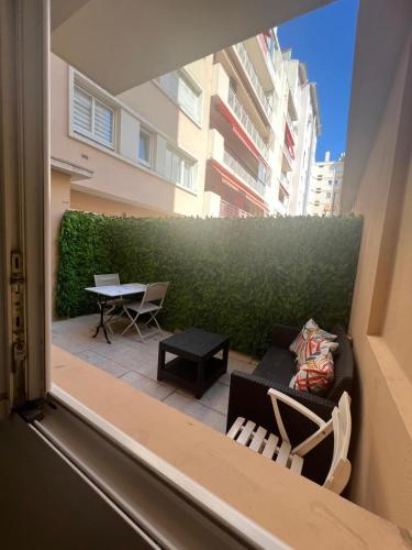 Elle offre une vue sur une terrasse dotée de chaises et d'une table. dans l'établissement Studio proche mer Antibes centre, à Antibes