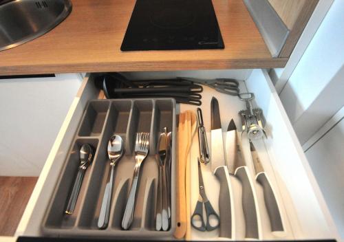 a drawer filled with utensils in a cabinet at BK Aparthotel Praga - National Stadium - Comfortable Apartment for 4 people in Warsaw