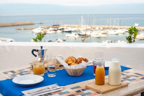 a table with food and drinks on a table with a view of a harbor at Hotel Terme Zi Carmela in Ischia