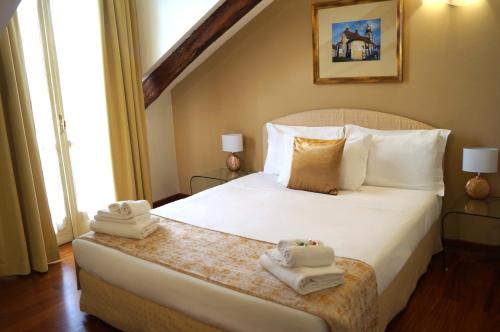 a bedroom with a bed with towels on it at Loger Confort Residence & Apartments in Turin