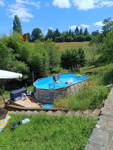 une grande piscine dans un champ à fonctionnalitésinsuffisantes dans l'établissement La Fontaine du Mas, à Thiviers