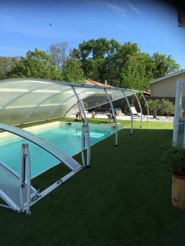 une piscine couverte avec une tente dans une cour dans l'établissement Les Tamaris d'Audenge, à Audenge