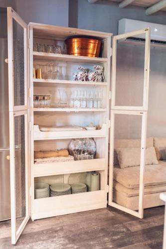 a white cabinet filled with dishes in a kitchen at La Casa del Jardín in Candeleda