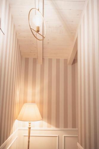 a lamp in a room with a striped wall at La Casa del Jardín in Candeleda