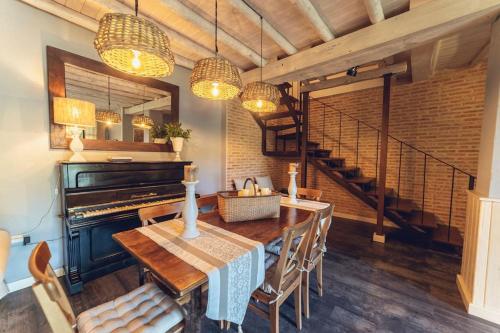 a dining room with a table and a piano at La Casa del Jardín in Candeleda