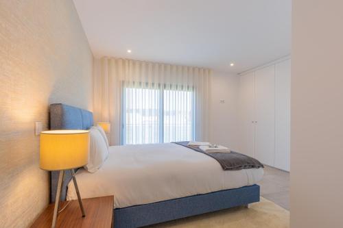 a bedroom with a large bed and a window at Luxuosa Villa Baía in Alfeizerão