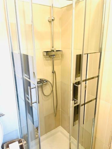 une douche avec une porte vitrée dans une salle de bain dans l'établissement Moderne, 2 chambres, 6 Couchages, EASY CHECK-IN, à Nice