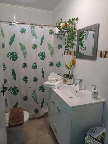 a bathroom with a shower curtain with plants on it at Quinta do Baquenéu- Sitio das Cortes in Cortes