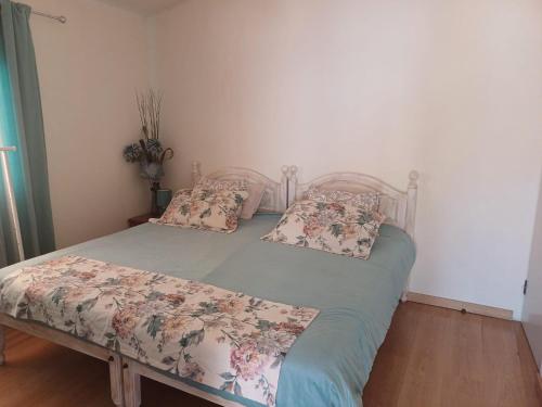 a bedroom with a bed with flowers on it at Quinta do Baquenéu- Sitio das Cortes in Cortes