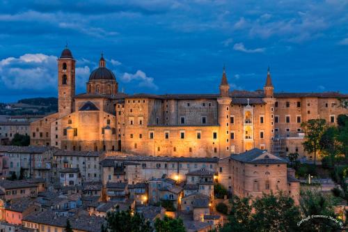 Un gran castillo en una ciudad por la noche. en Elena's Guest House, en Urbino