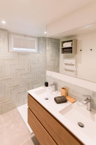 une salle de bain avec un lavabo et un miroir dans l'établissement Laventoliere Trouville, à Trouville-sur-Mer