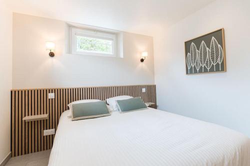 une chambre avec un lit blanc et une fenêtre dans l'établissement Laventoliere Trouville, à Trouville-sur-Mer