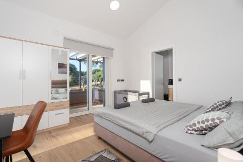 a bedroom with a bed and a desk and a chair at Villa Croatia Heaven in Lun