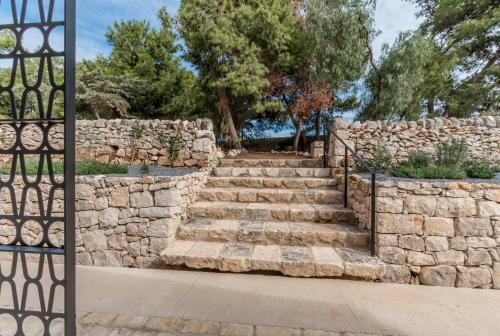 a stone wall and stairs with a gate at Mangiabove in Marina di Ragusa
