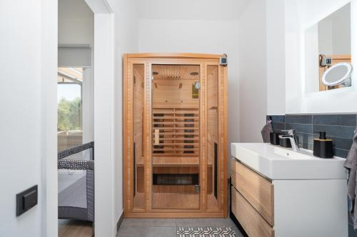 a bathroom with a wooden cabinet next to a sink at Villa Croatia Heaven in Lun