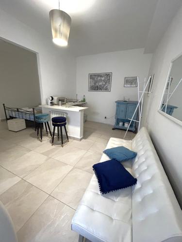 a living room with a white couch and a kitchen at Allegra Toscana - Affittacamere Guest house Arezzo in Arezzo
