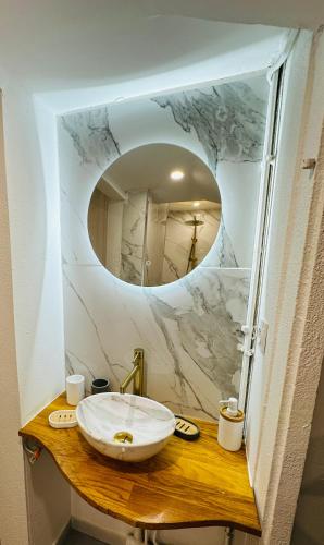 une salle de bain avec un lavabo et un miroir dans l'établissement Le Petit Bourbonnais, à Moulins