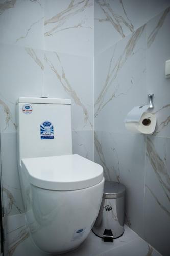 a white toilet in a bathroom with marble walls at Qadim Hotel in Samarkand