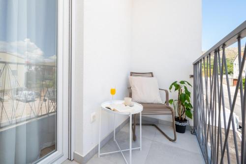 a balcony with a chair and a table and a window at Apartment SarAna Trogir in Trogir