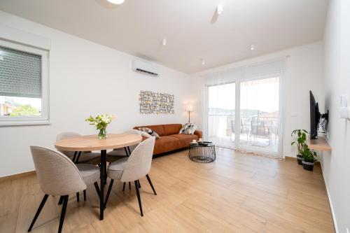 a living room with a table and chairs and a couch at Apartment SarAna Trogir in Trogir