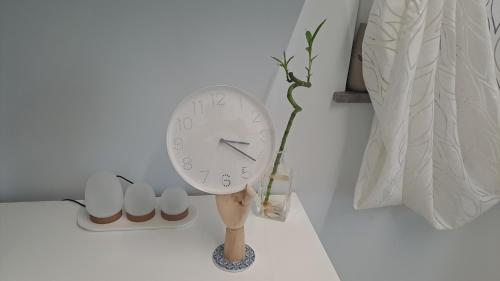 a clock on a stand next to a wall at Casacocco' - Agri Host in San Ginesio