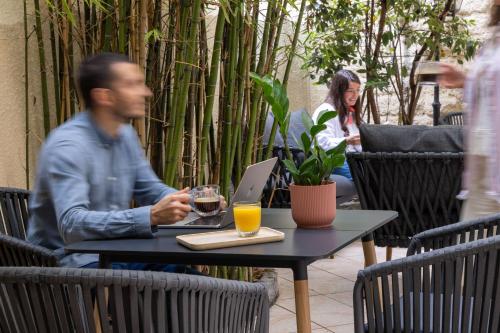 a man sitting at a table with a laptop at Korner Montmartre in Paris