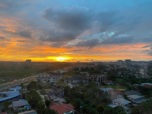 a city skyline with a sunset in the background at Manhattan Suite ITCC by 8Avenue in Kota Kinabalu