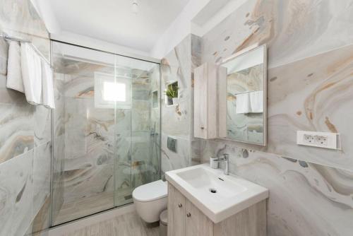 a bathroom with a sink and a toilet and a mirror at G Berdufi 2 bd with parking in Eloúnda in Elounda