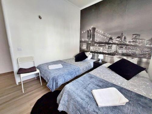a bedroom with two beds and a wall with a picture at Sea View 2-beds 'Estrela' Apartment - Praia da Luz in Luz