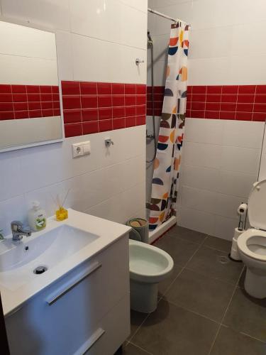 a bathroom with a sink and a toilet and a mirror at Sol in Cangas de Morrazo