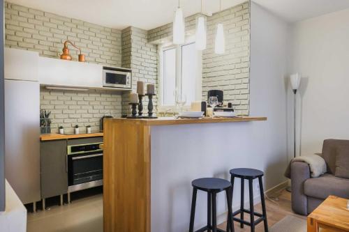 une cuisine avec un comptoir et des tabourets dans une pièce dans l'établissement Modern flat - 1BD-4P - Parc Monceau, à Paris