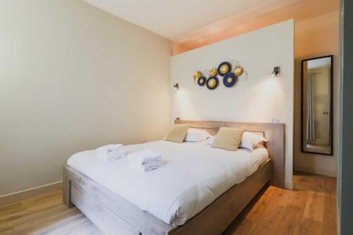 une chambre avec un grand lit avec des draps blancs dans l'établissement Modern flat - 1BD-4P - Parc Monceau, à Paris