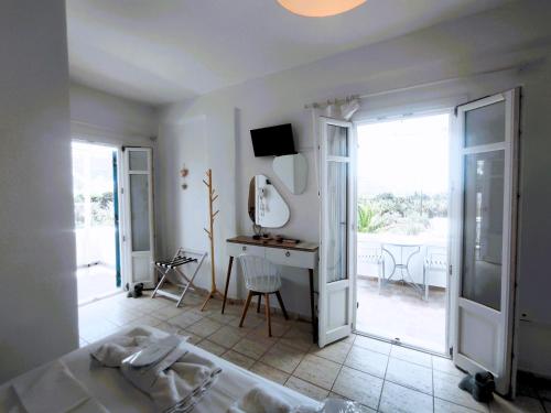 a bedroom with a bed and a table and a desk at Villa Le Grand Bleu in Katapola