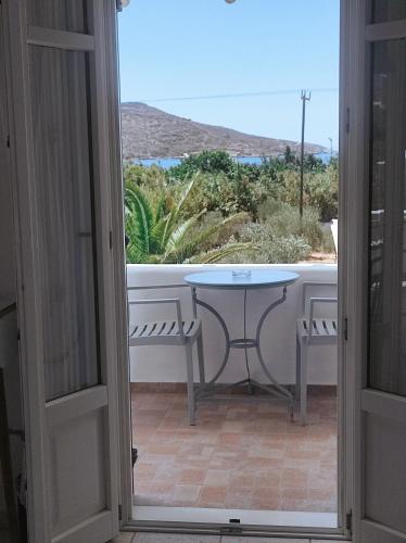a door open to a patio with a table and a view at Villa Le Grand Bleu in Katapola