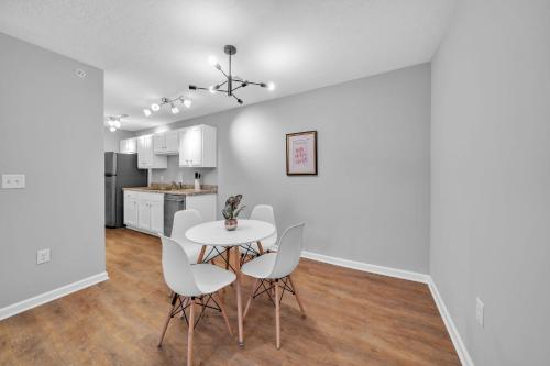 a kitchen and dining room with a white table and chairs at Stonecrest 910, 2bd Apt I Free Parking I Pool in New Albany